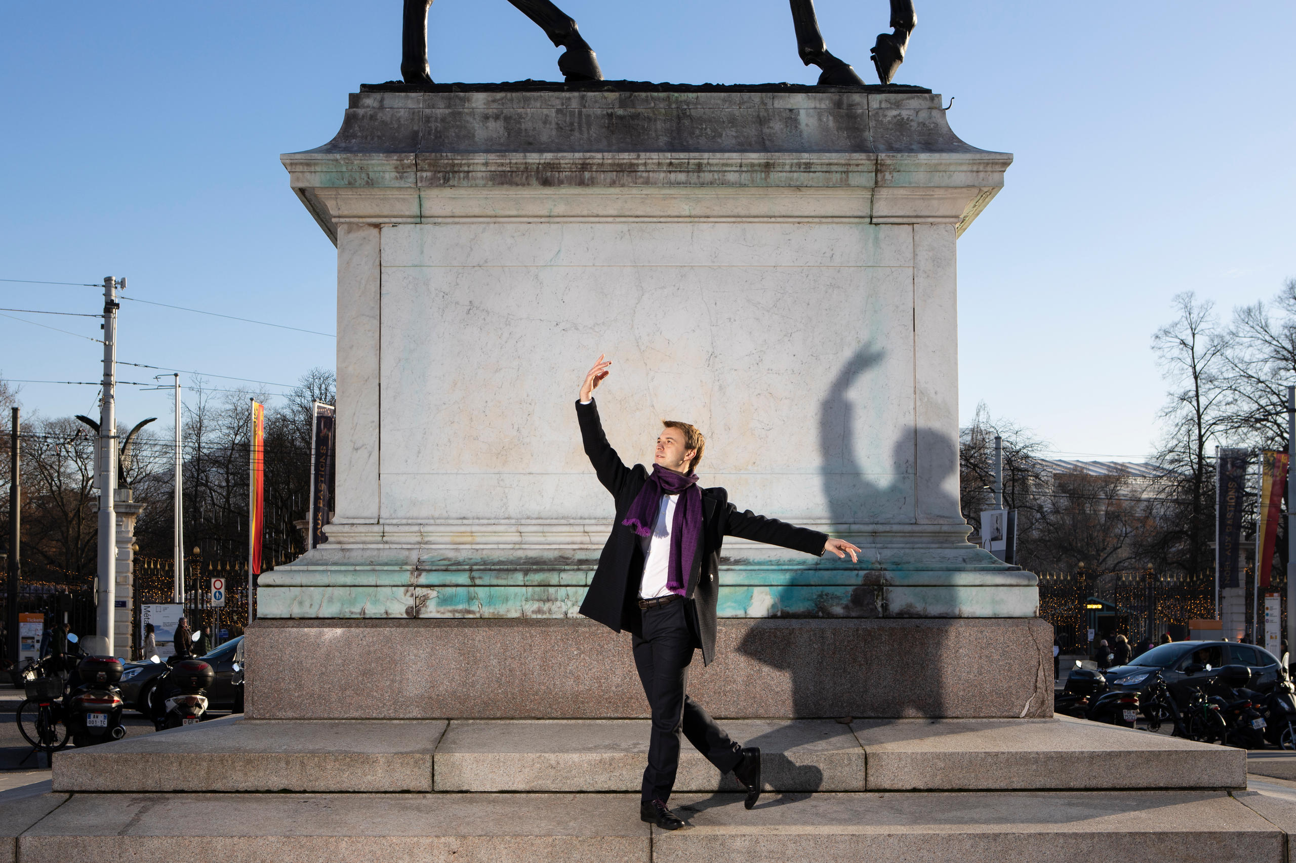 Homme dansant devant une statue