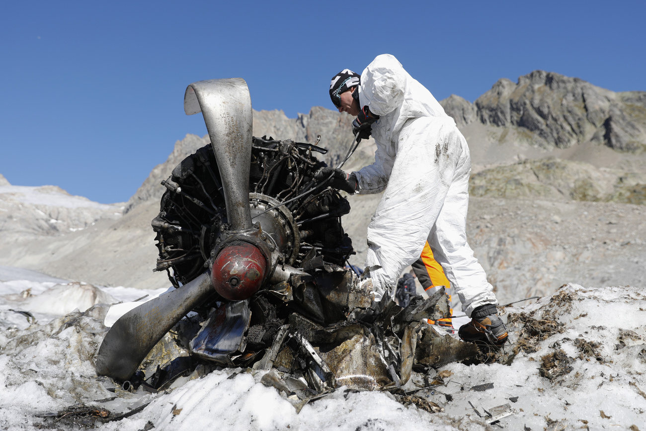 Ein Mann untersucht den Propeller eines Flugzeuges im Schnee