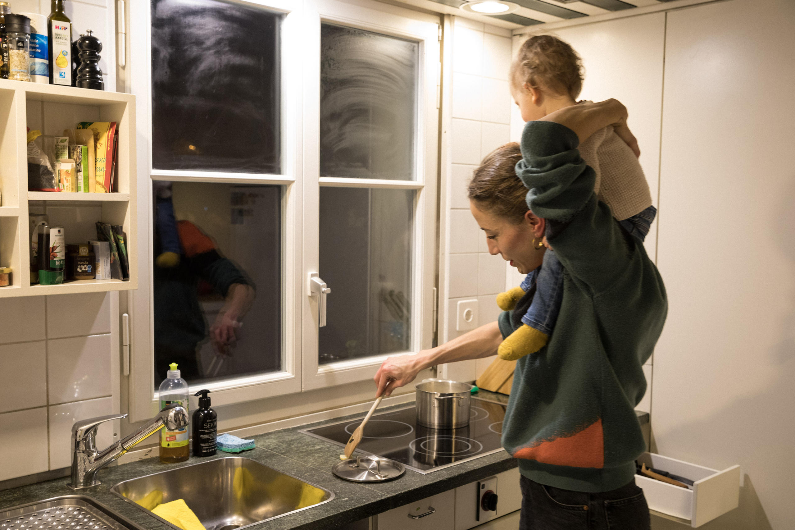 Ambra sur les épaules de Sarah, qui fait la cusine