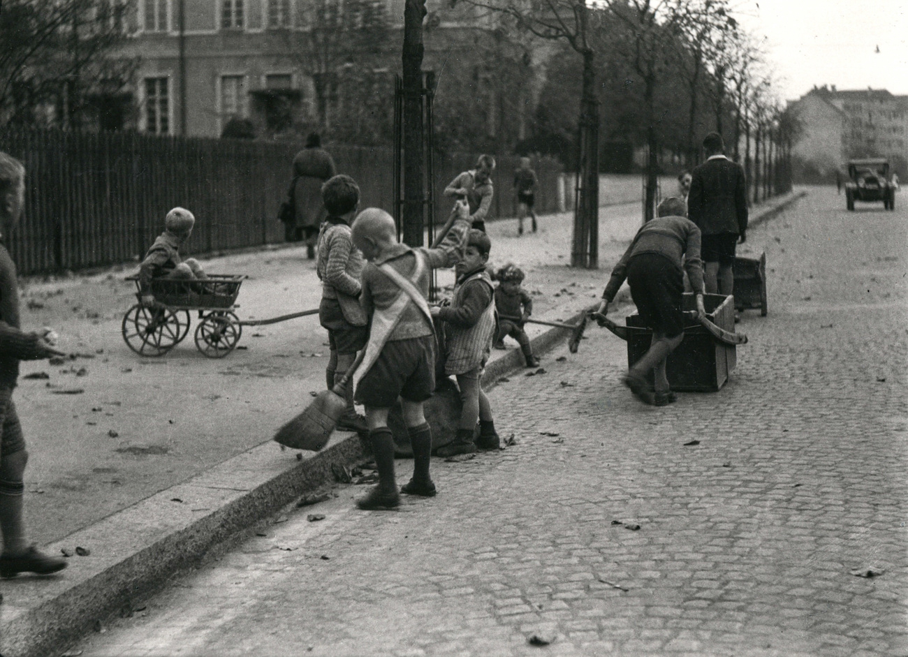 Niños limpiando la calle y recogiendo hojas, aprox 1933.