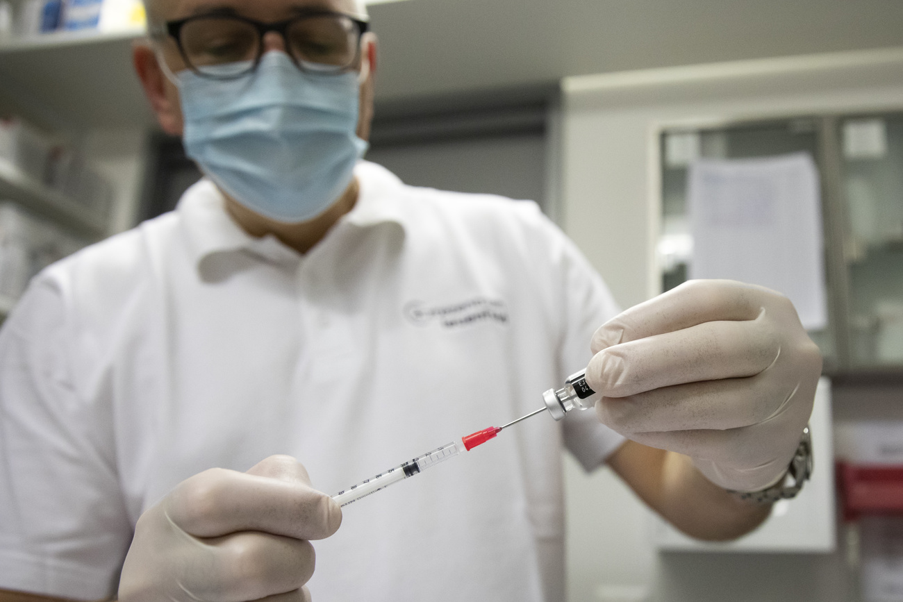 A family doctor prepares the Pfizer-BioNTech jab at his practice in Oensingen on Saturday, 16 January