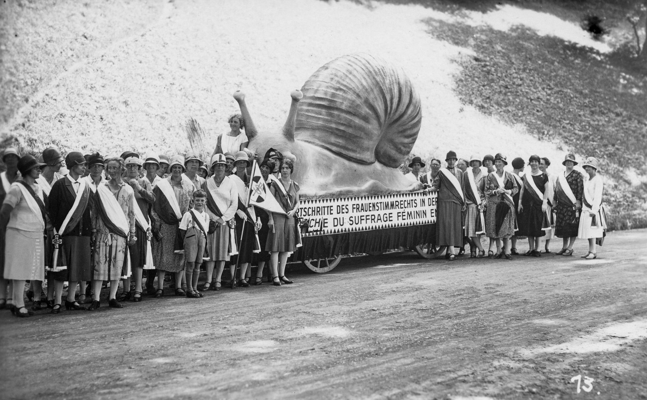 Manifestación de mujeres con una escultura gigante de caracol