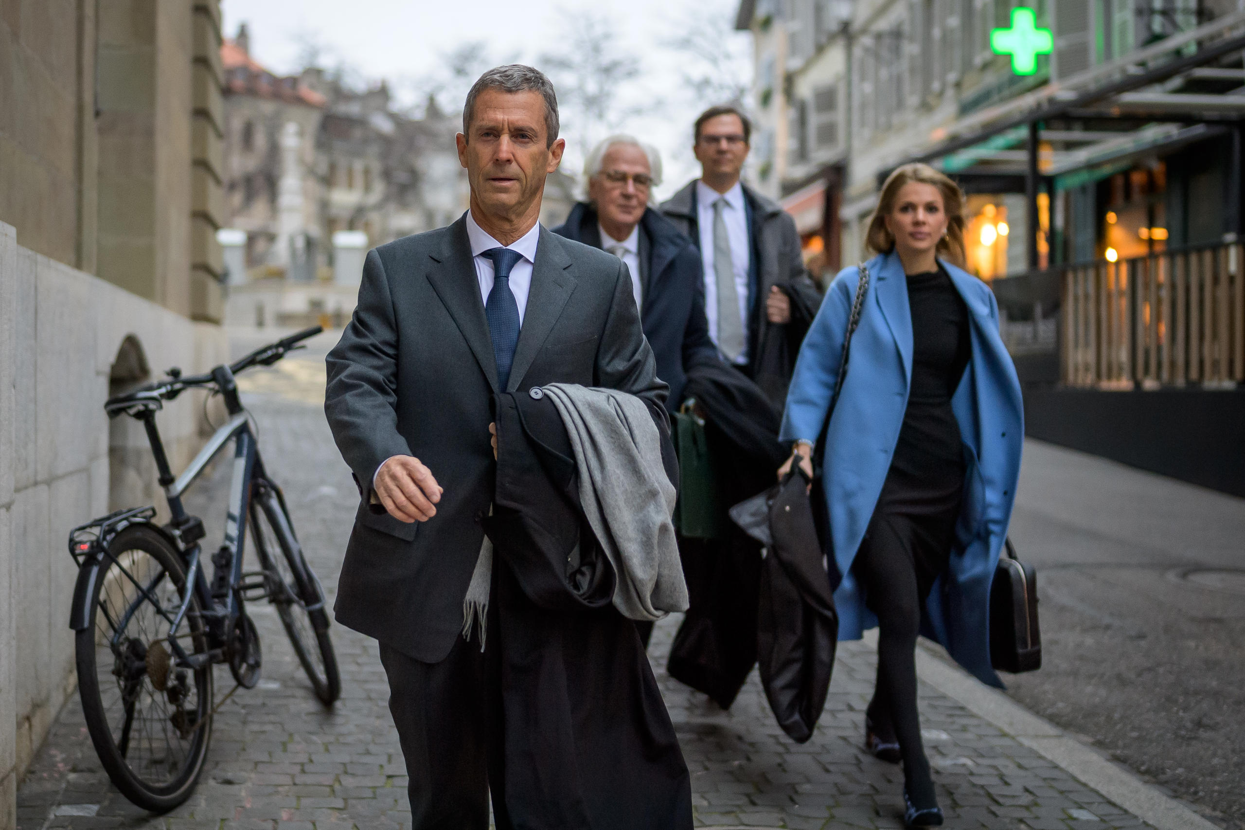 Un homme d affaires entouré de ses avocats dans une rue de Genève.