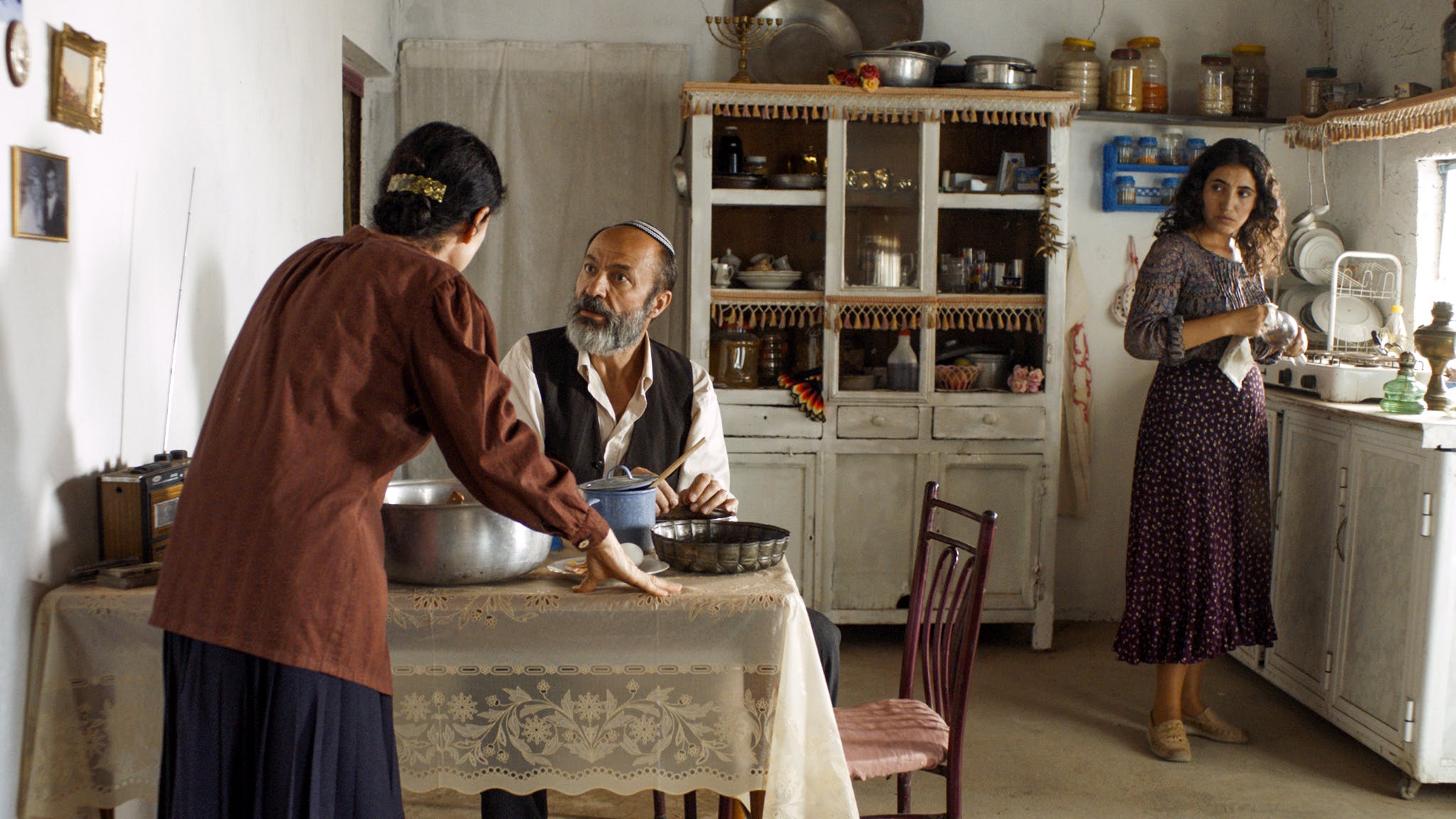 Três pessoas em uma cozinha oriental