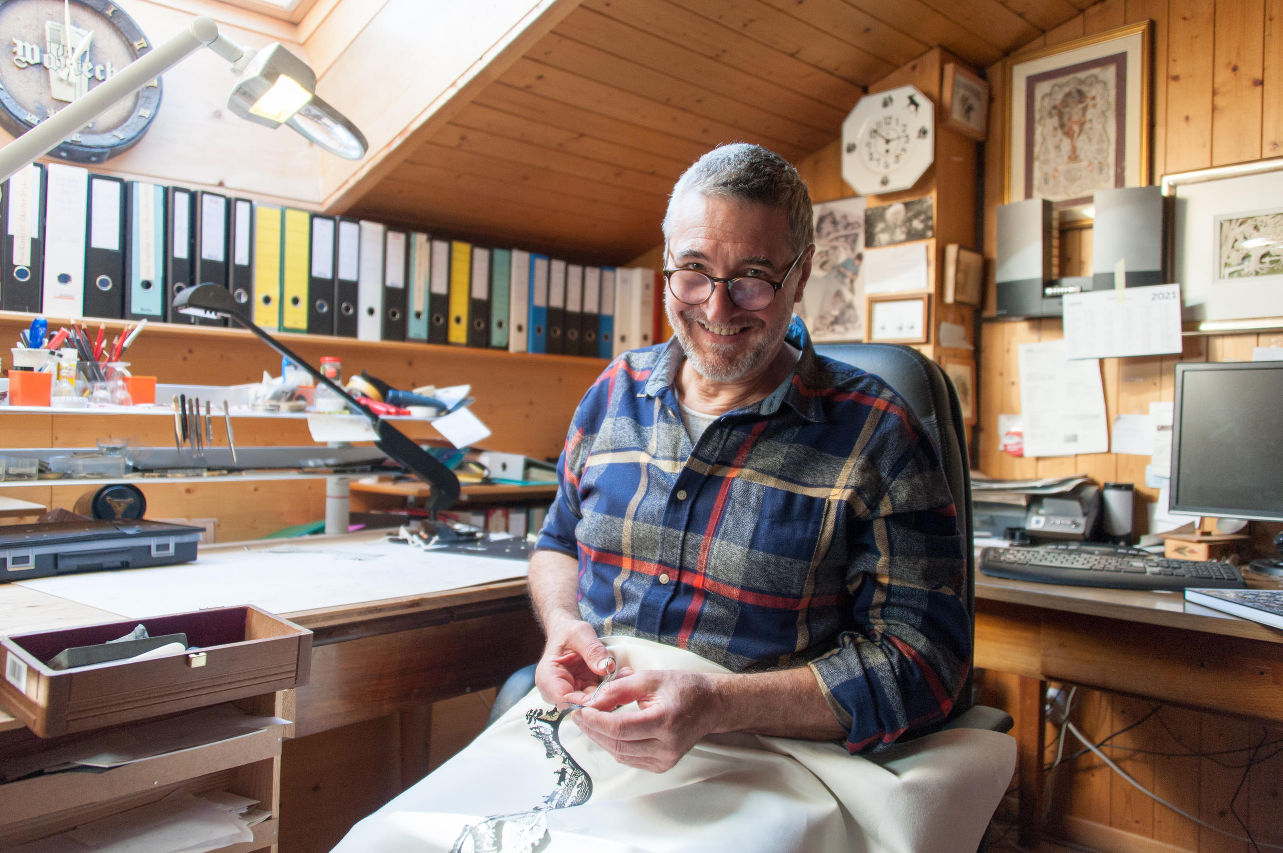 Homme assis en train de faire un découpage sur papier.