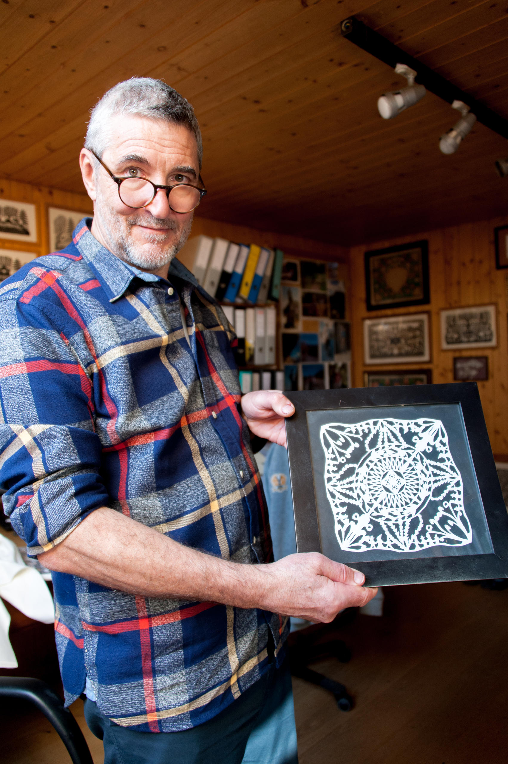 切り絵作品を見せるグラッツさん