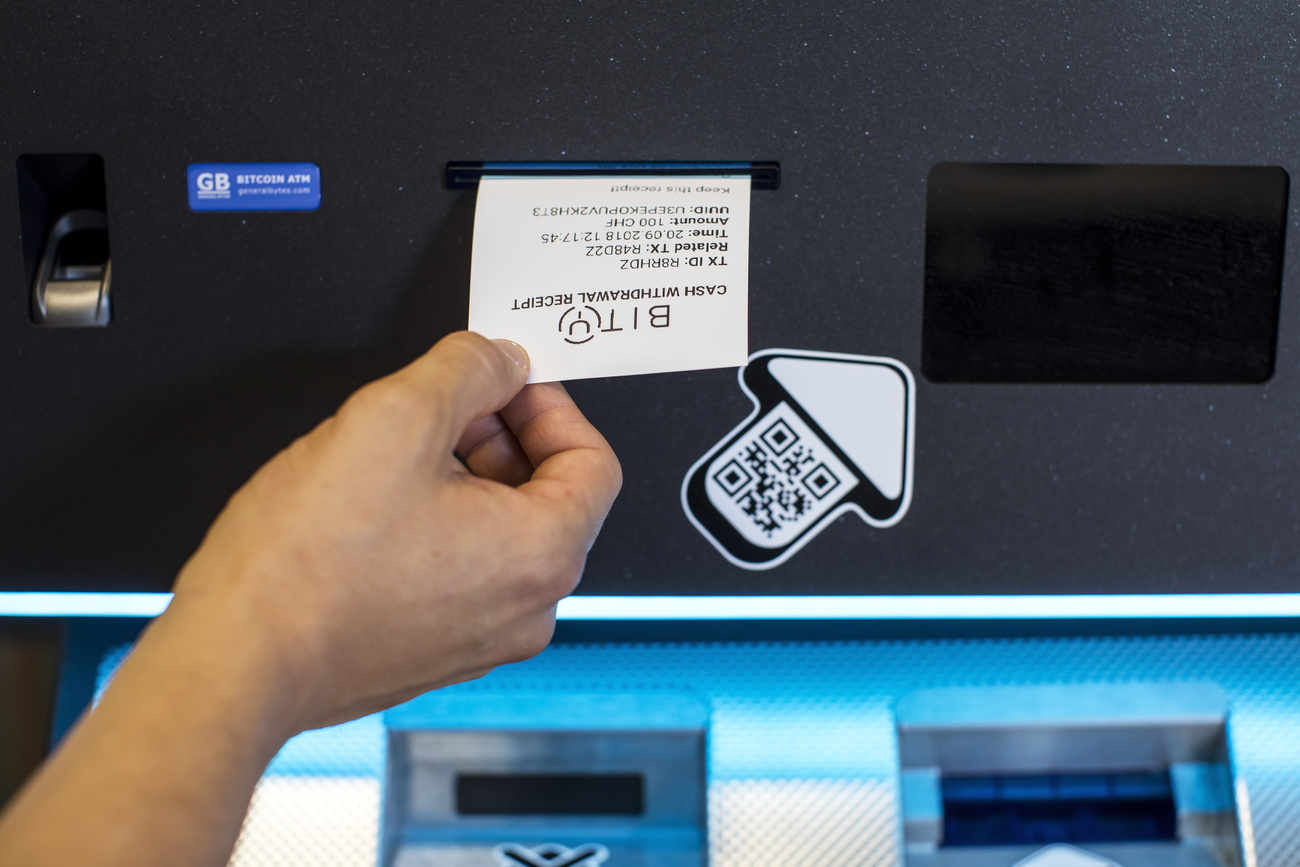 Mano riceve uno scontrino su carta termina con scritto BIT da un distributore automatico