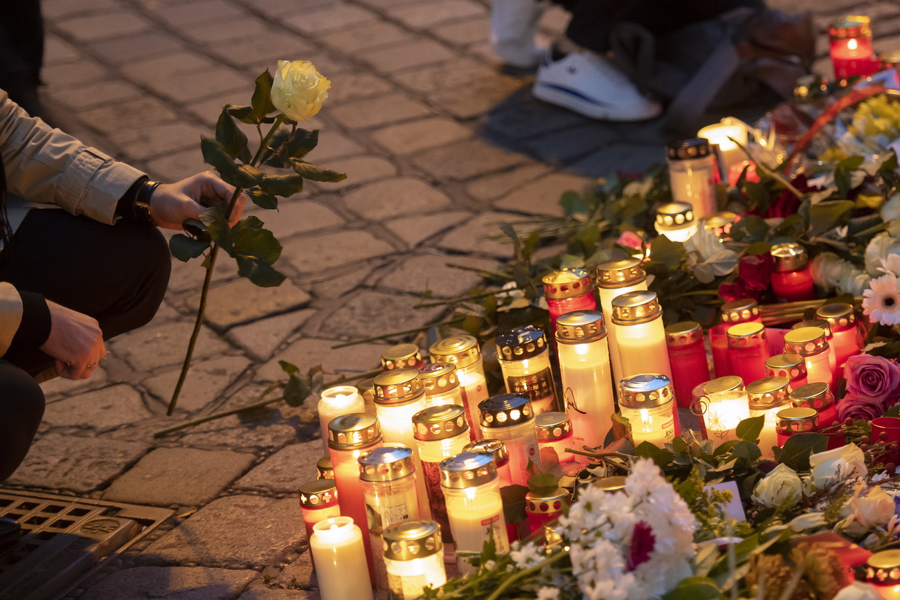 Person holds flower by candles