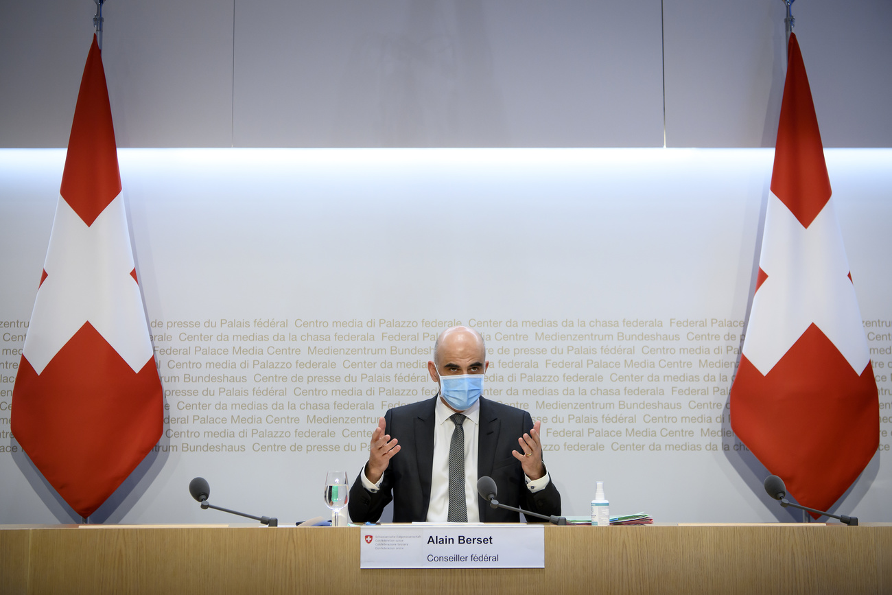 Alain Berset durante la conferenza stampa tra due bandiere svizzere