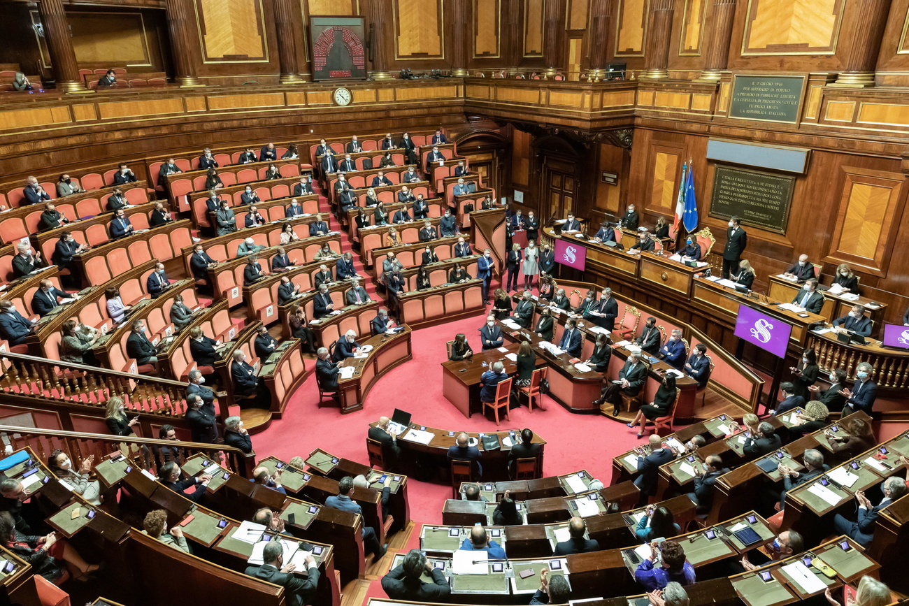 Vista panoramica di traverso dell aula del Senato, un uomo in piedi parla al plenum da uno scranno centrale.