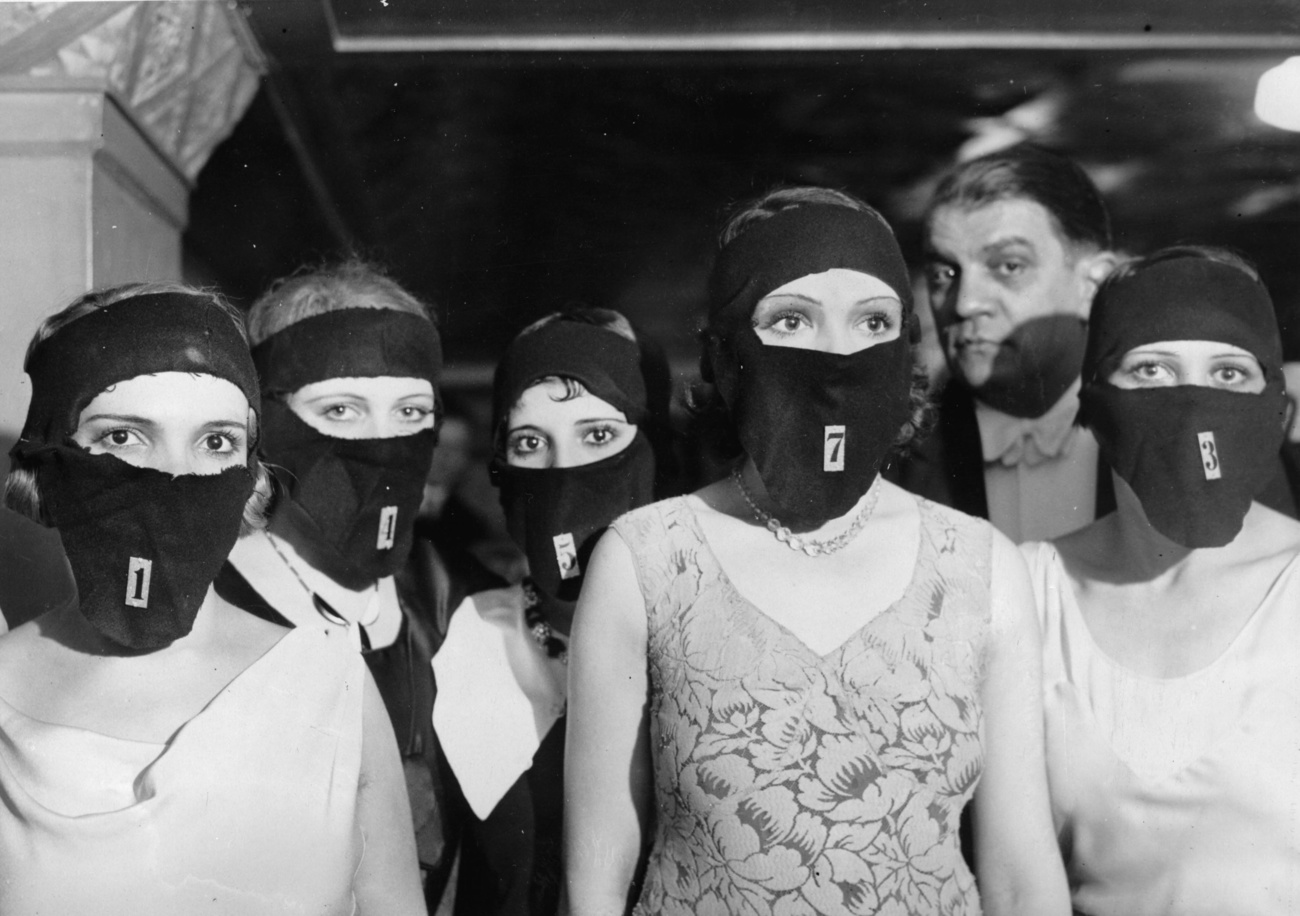 صورة بالأبيض والأسود لنساء يرتدين أقنعة على وجوههن