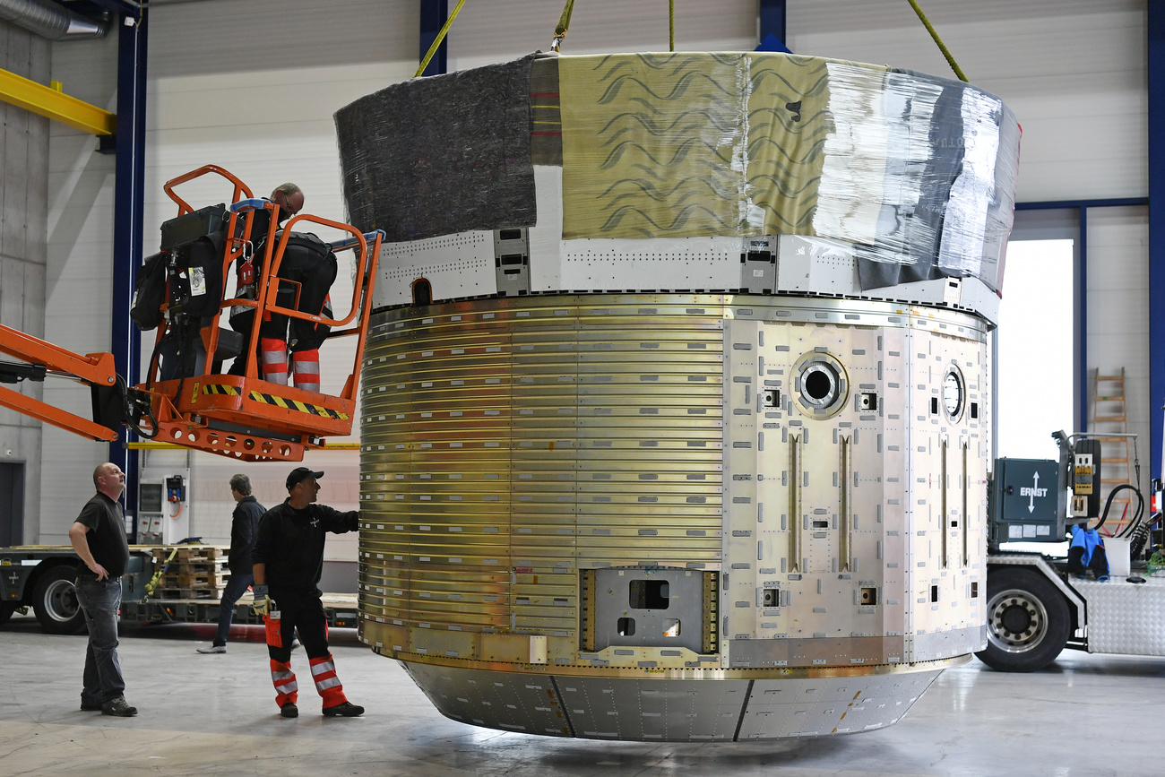 Workers in a Ruag factory with a space transfer vehicle