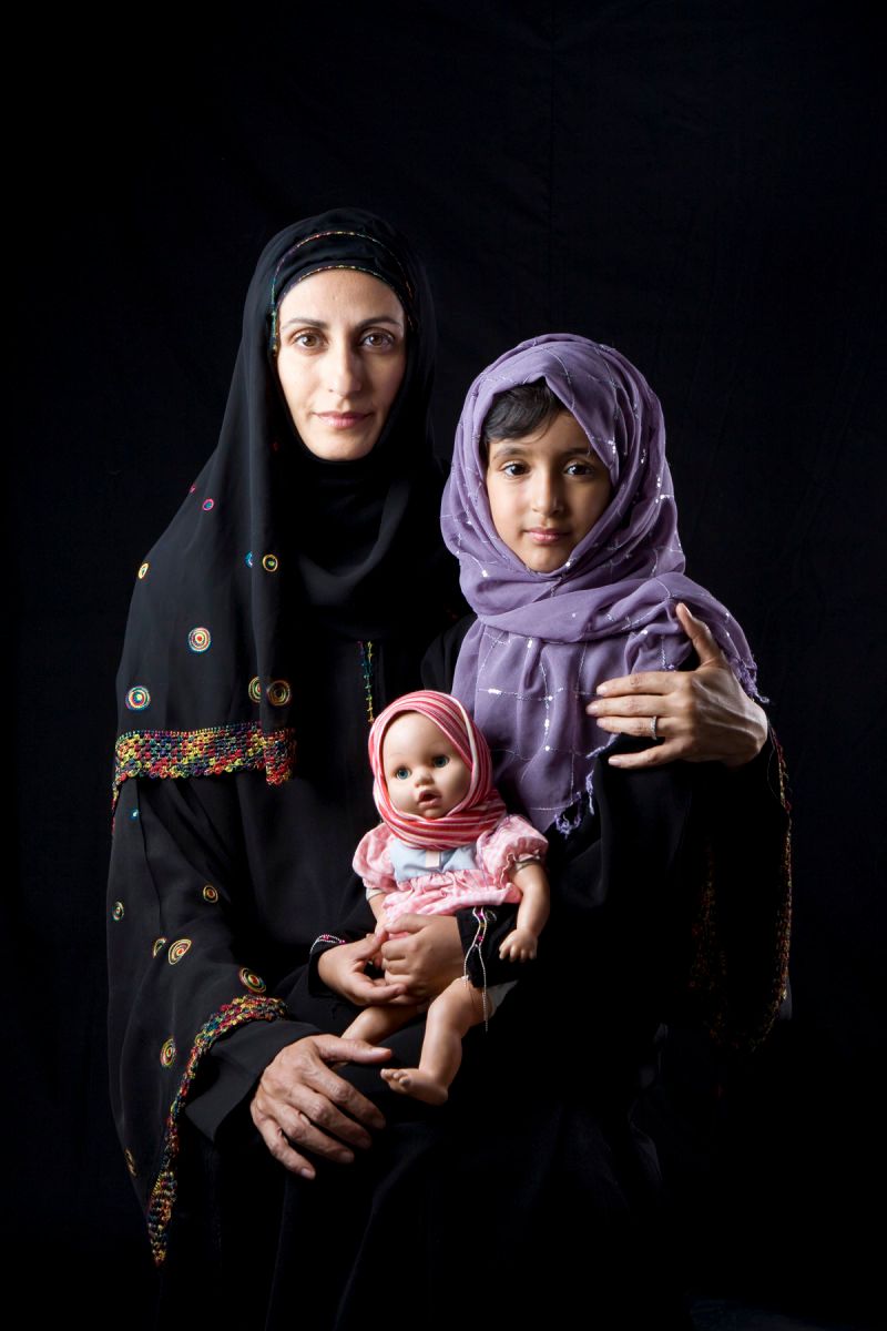 Mujer, niña y muñeca con vestimenta occidental