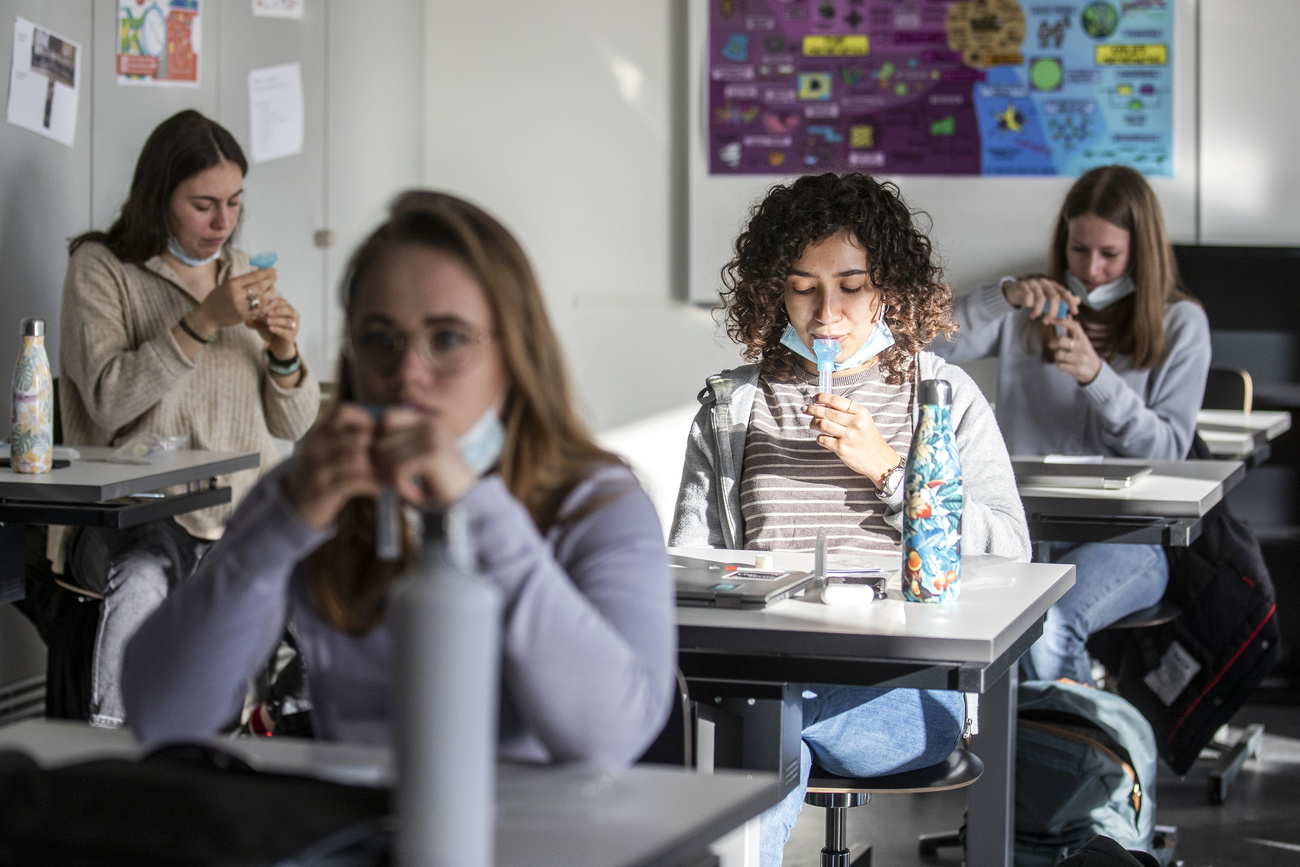 Alumnas en clase se aplican un test de saliva