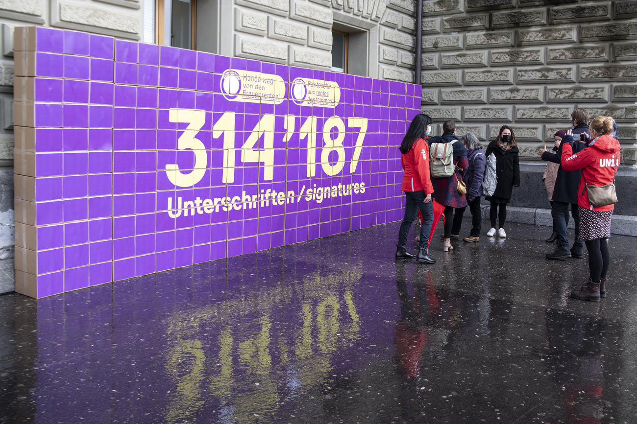 gruppo di donne davanti a un cartellone con la scritta 314187