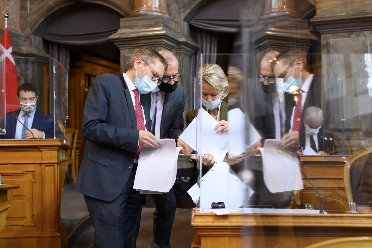 Group of parliamentarians in the Swiss senate comparing documents