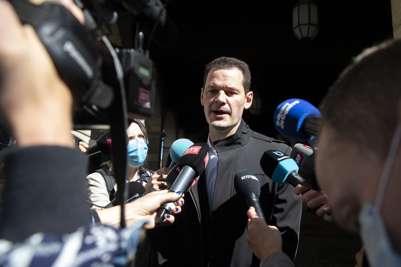 Man speaking in front of reporters holding mics