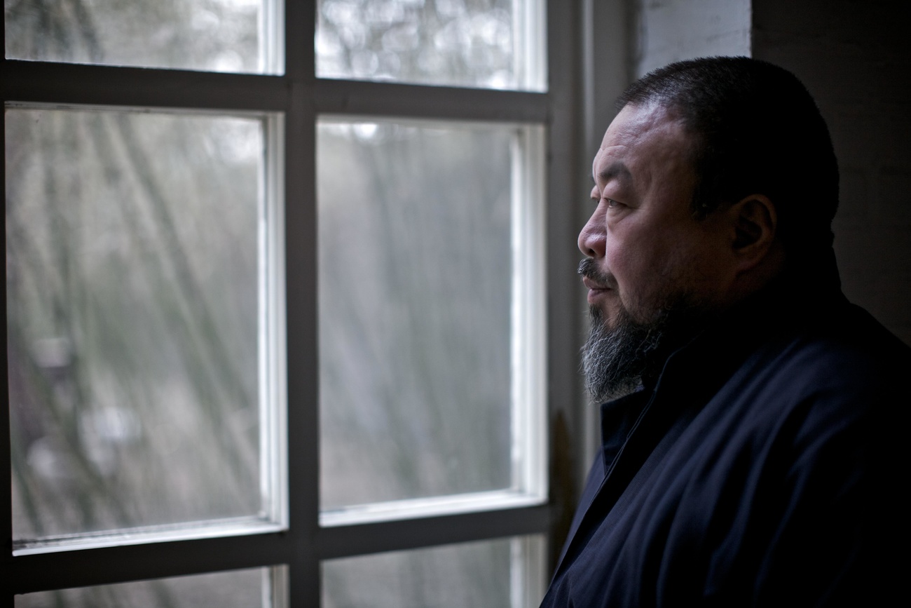 Ai Weiwei looking through a window