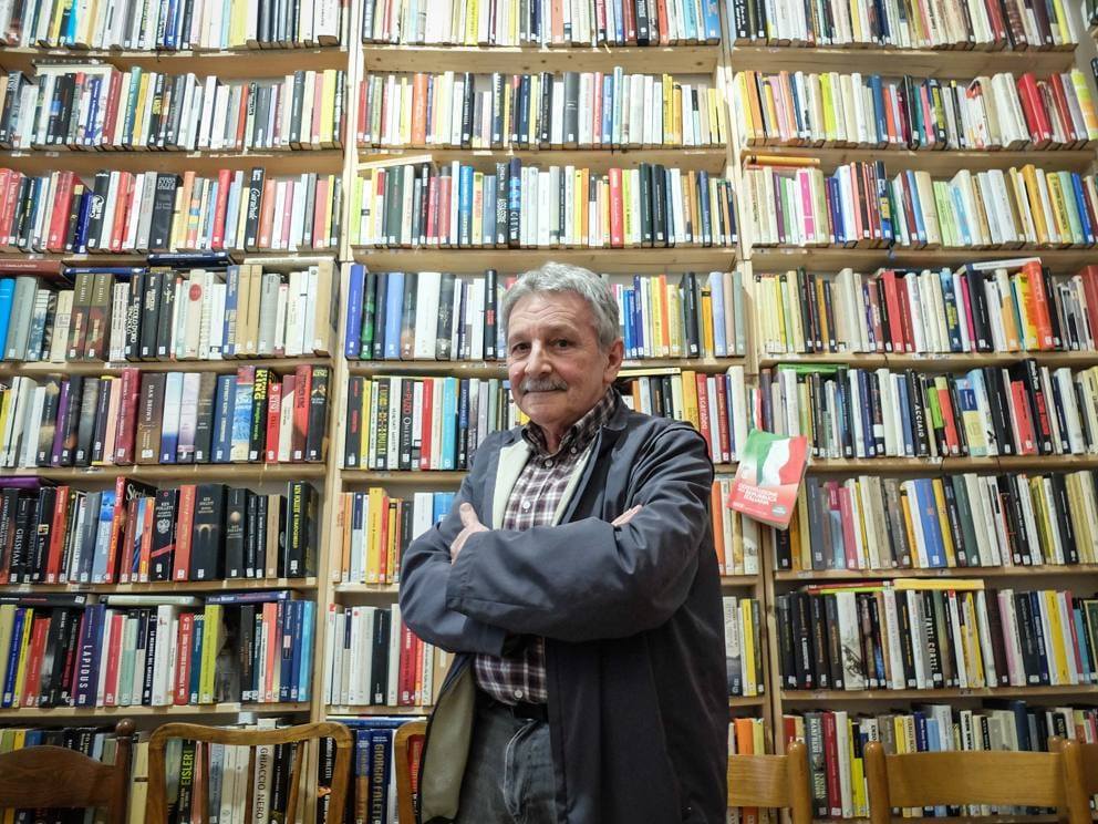 L ideatore Roberto posa davanti agli scaffali della biblioteca