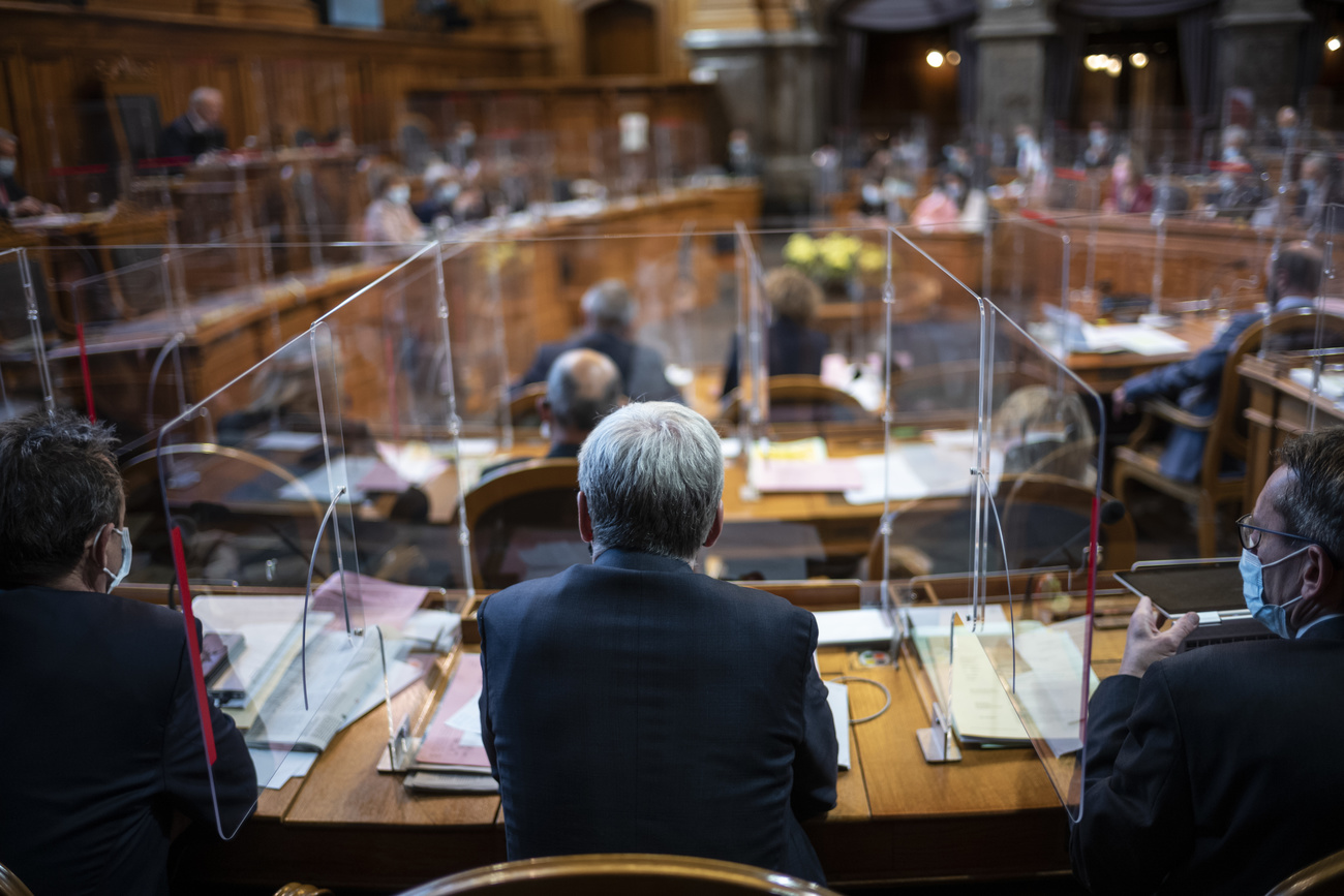 Veduta di una sala parlamentare con postazioni separate da pannelli di plexiglass e plastica sui paravento dei microfoni