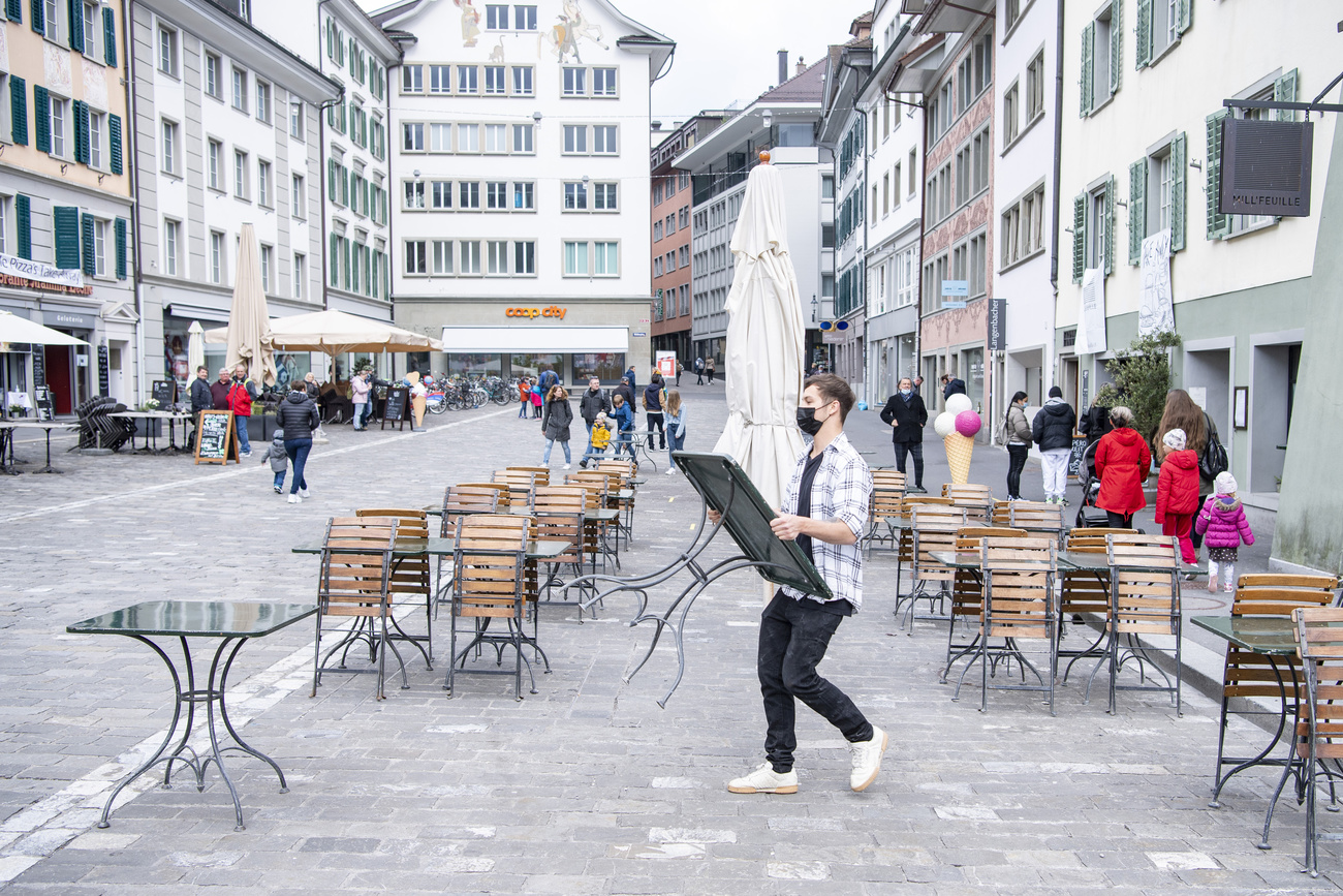 Un uomo sta attrezzando la terrazza del ristorante.
