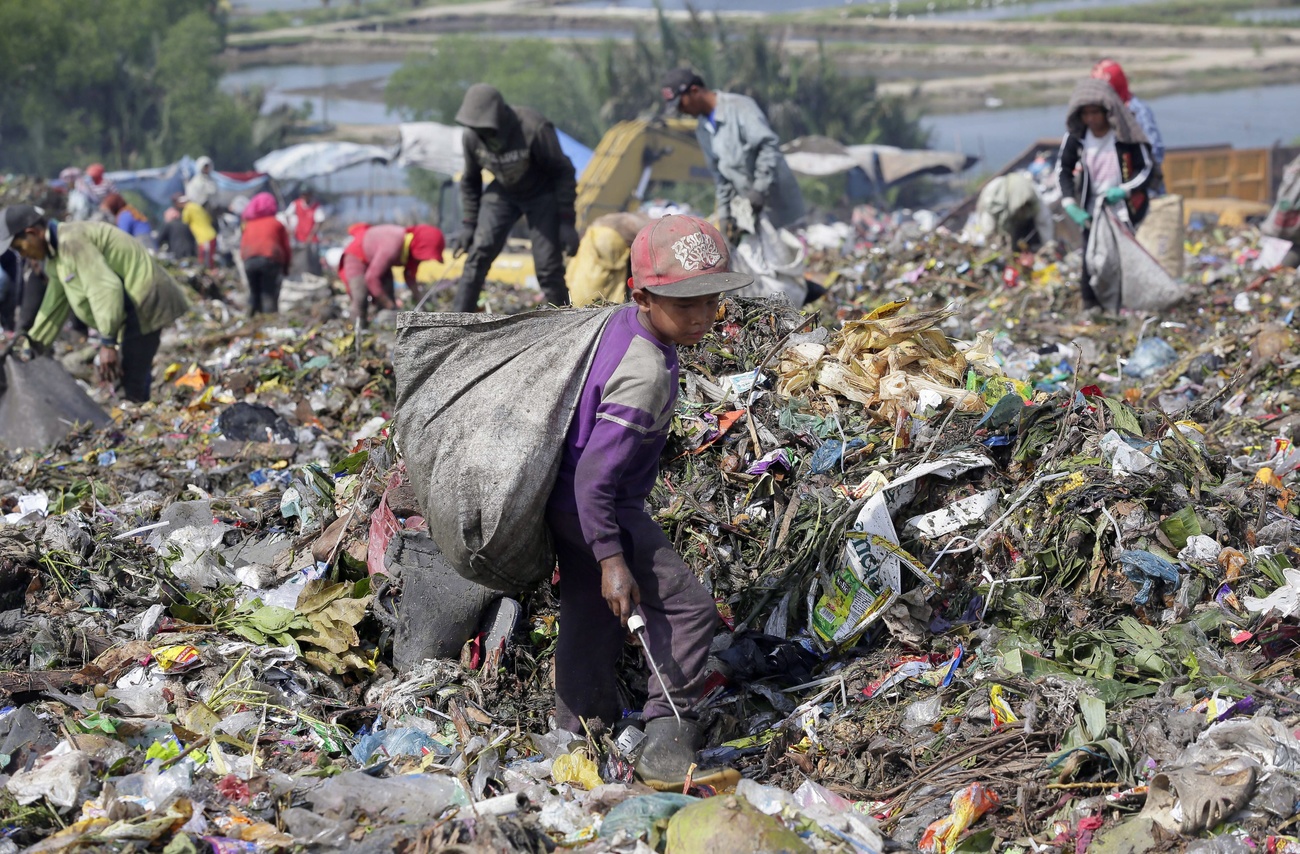 A boy aged 7 collects recyclable materials at a dumpsite in Marelan, Medan, North Sumatra Province, Indonesia.