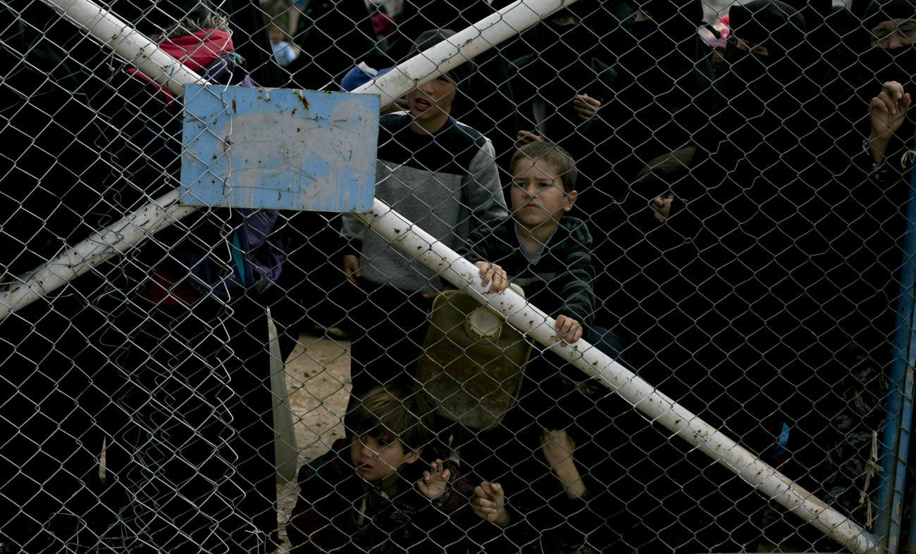 Niños tras un alambrado