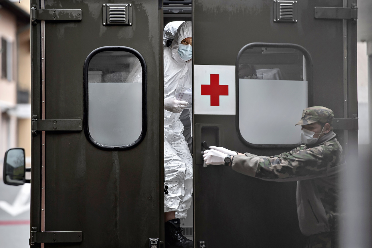 Porta ospedale si apre, persone con mascherina