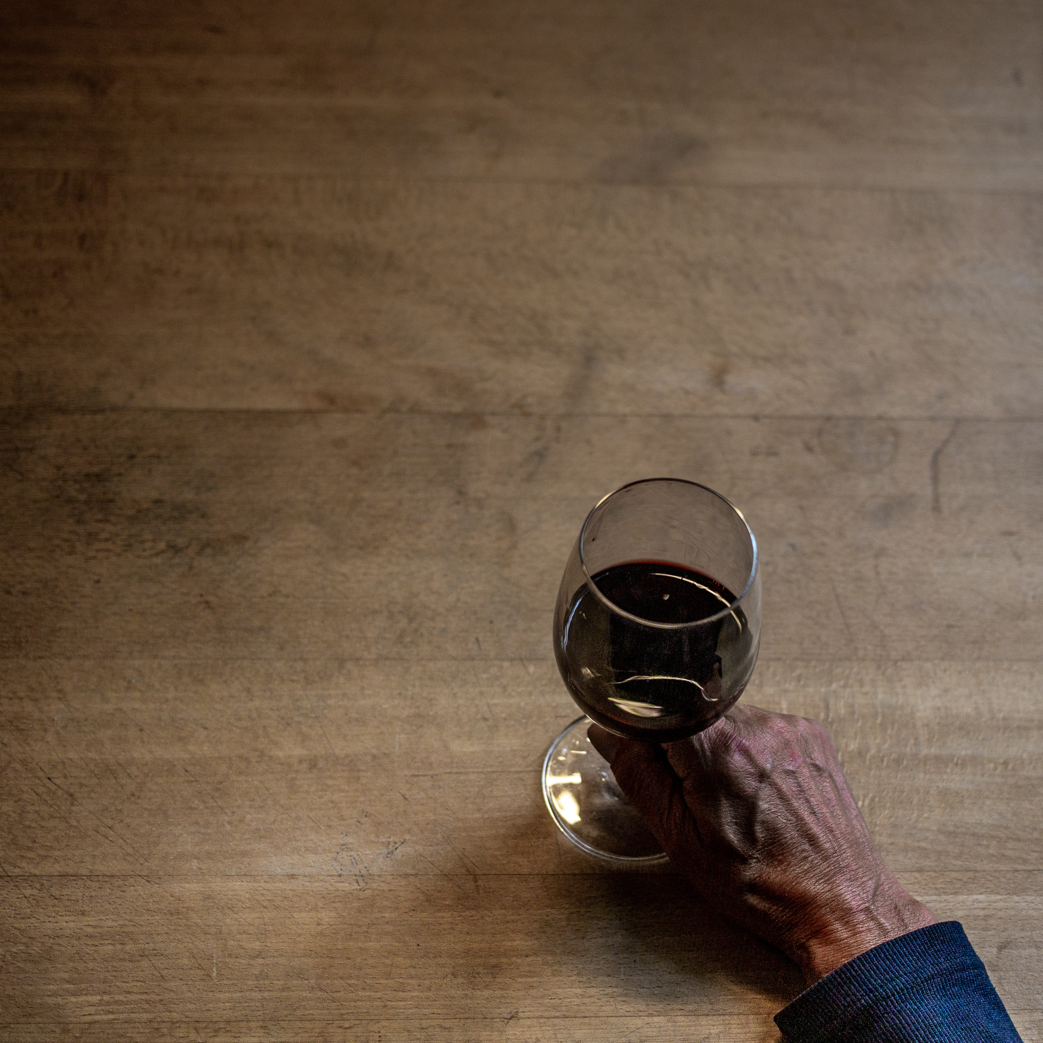 Main tenant un verre de vin sur une table