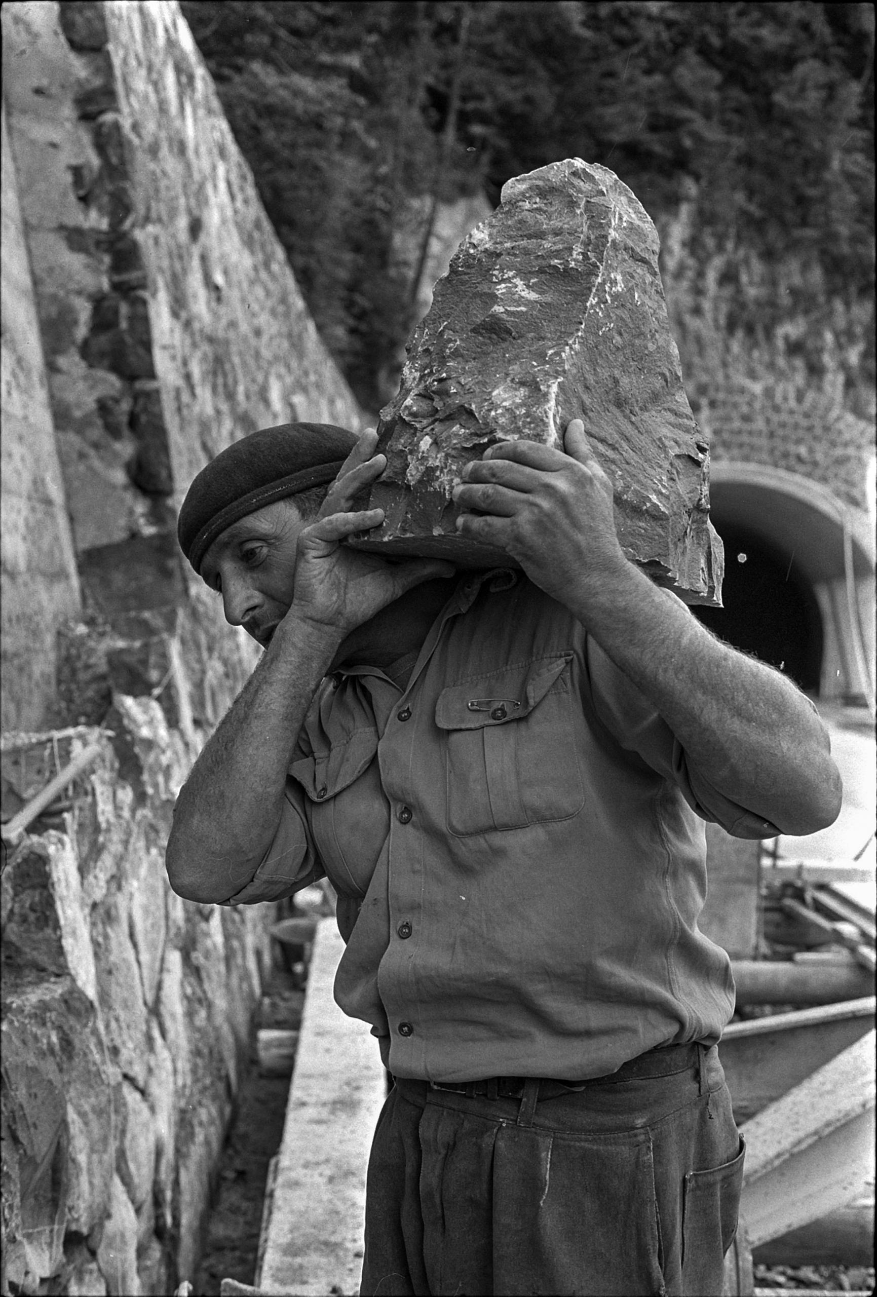 Trabajador con una piedra al hombro