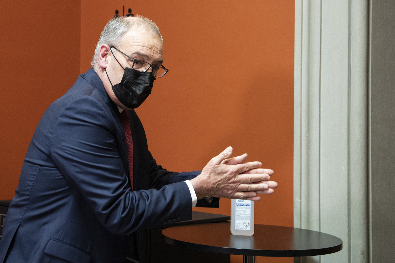 Il presidente Parmelin si disinfetta le mani dopo la seduta con la Commssione
