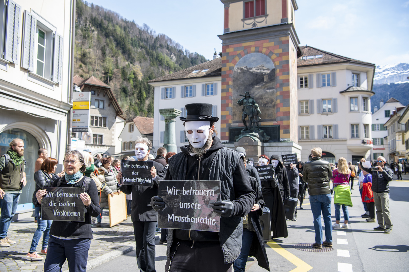 Protestors wearing black and holding placards