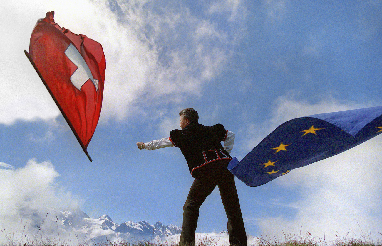 Uno sbandieratore con le bandiere di Ue e Svizzera.