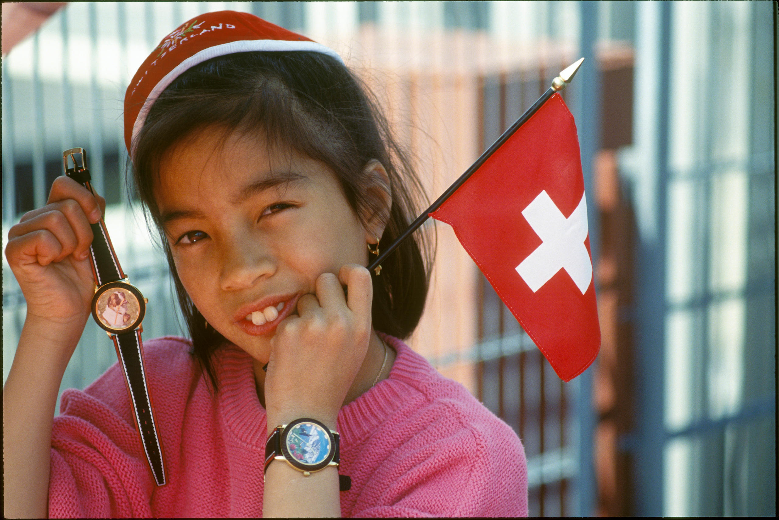 bambina che tiene un orologio e una bandierina svizzera