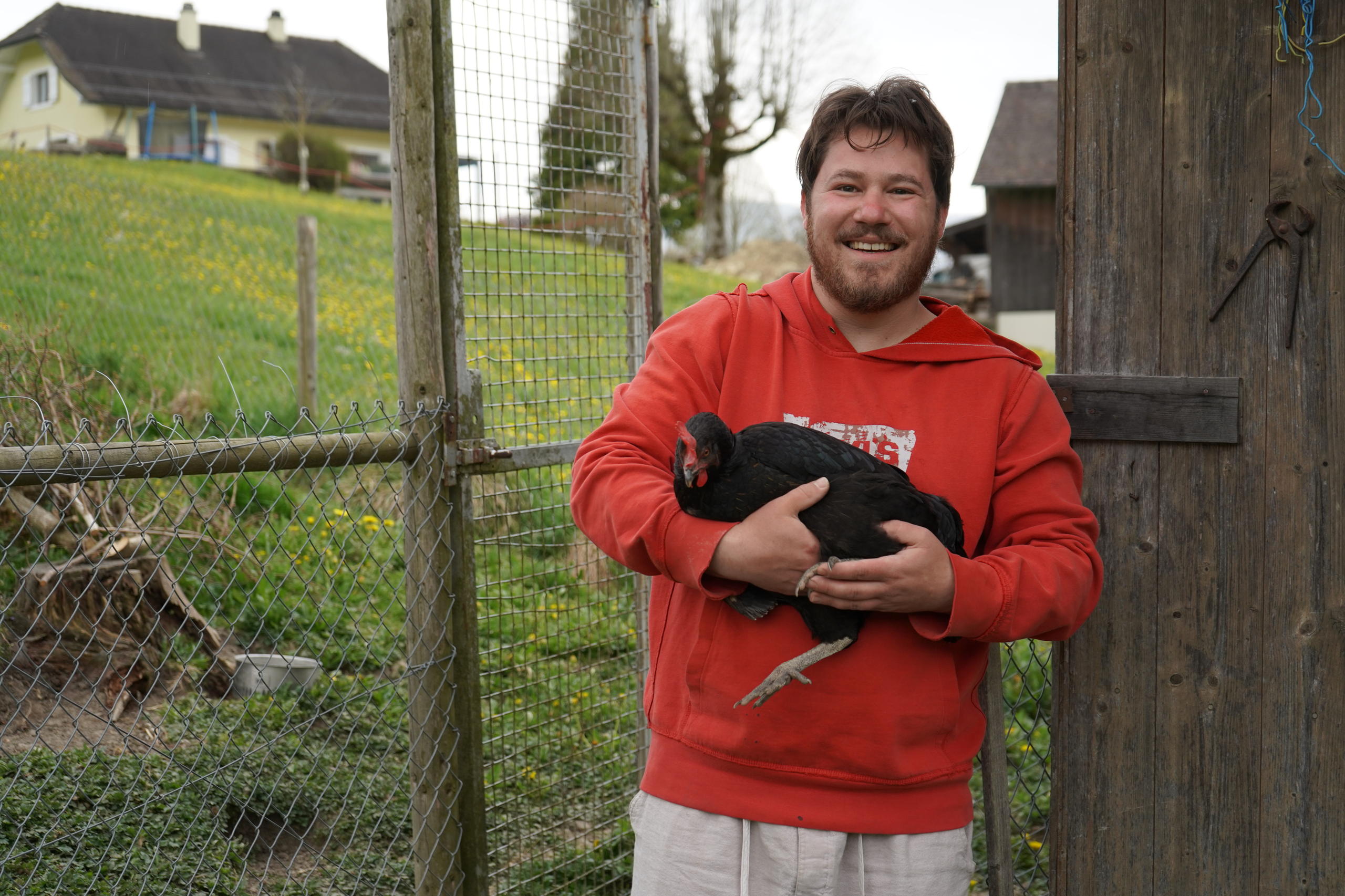 Un homme tenant une poule