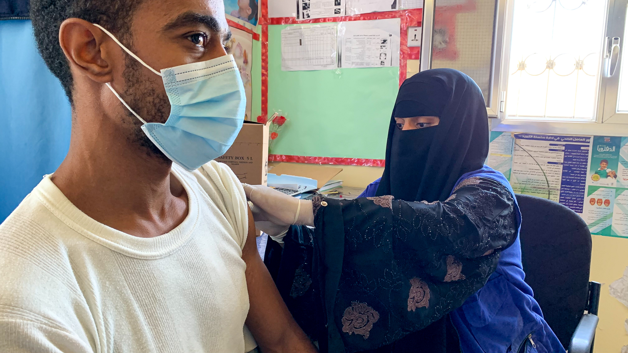ممرضة تقوم بتلقيح مهاجر في اليمن