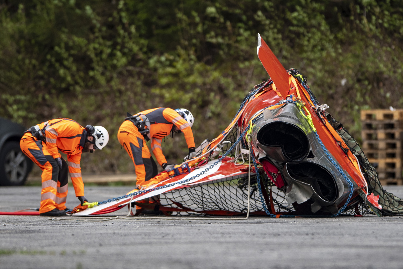 Salvage workers with a part of the crashed aircraft