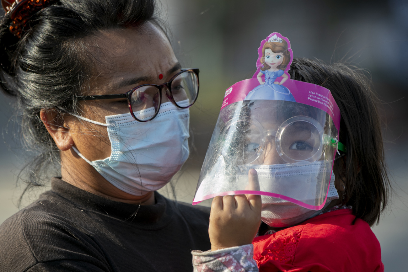 Eine nepalesische Frau und ihre Tochter mit Maske und Visier