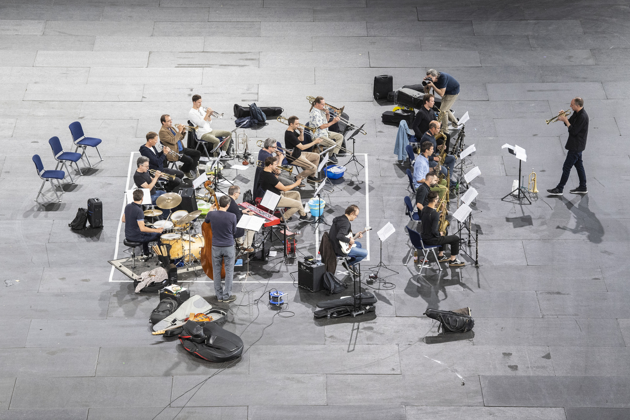 Un orchestra di (si intuisce dagli strumenti) jazz, tipo big band, disposta per un concerto su un piazzale