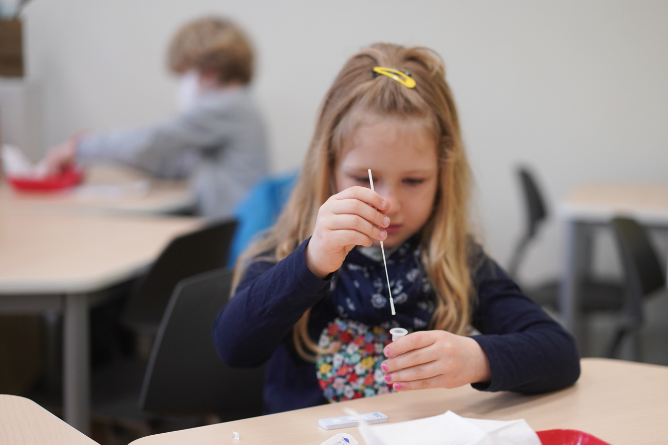 Una bimba effettua un test con tampone a scuola