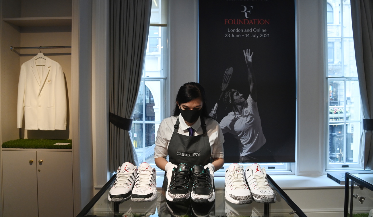 Une employée de Christie s devant une affiche de Federer