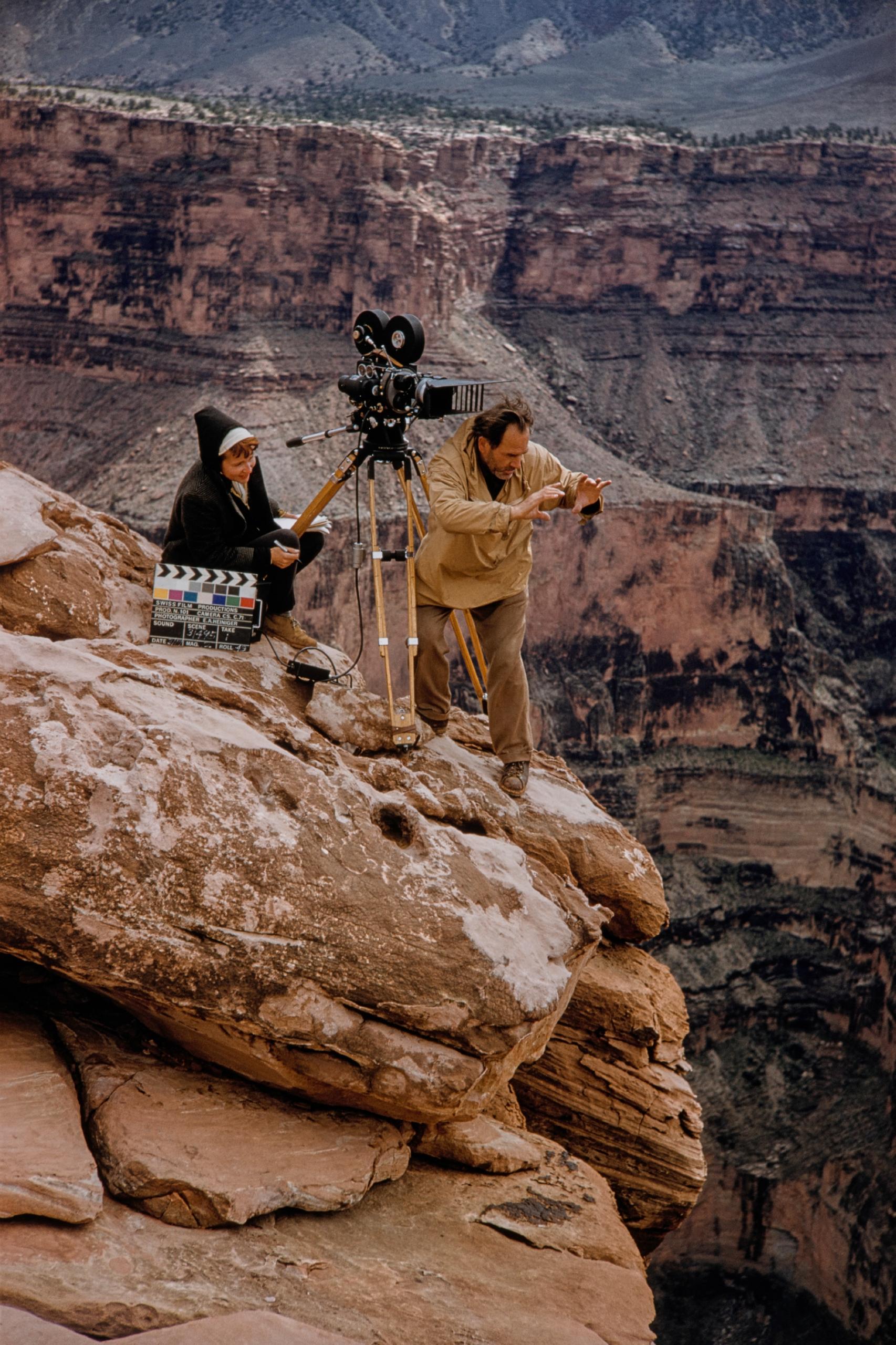 Mujer y hombre en lo alto de una montaña con cámara de cine