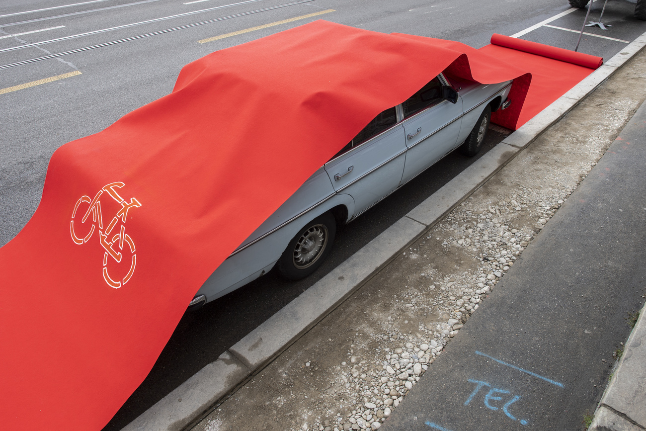 Parked car covered with red bike lane carpet