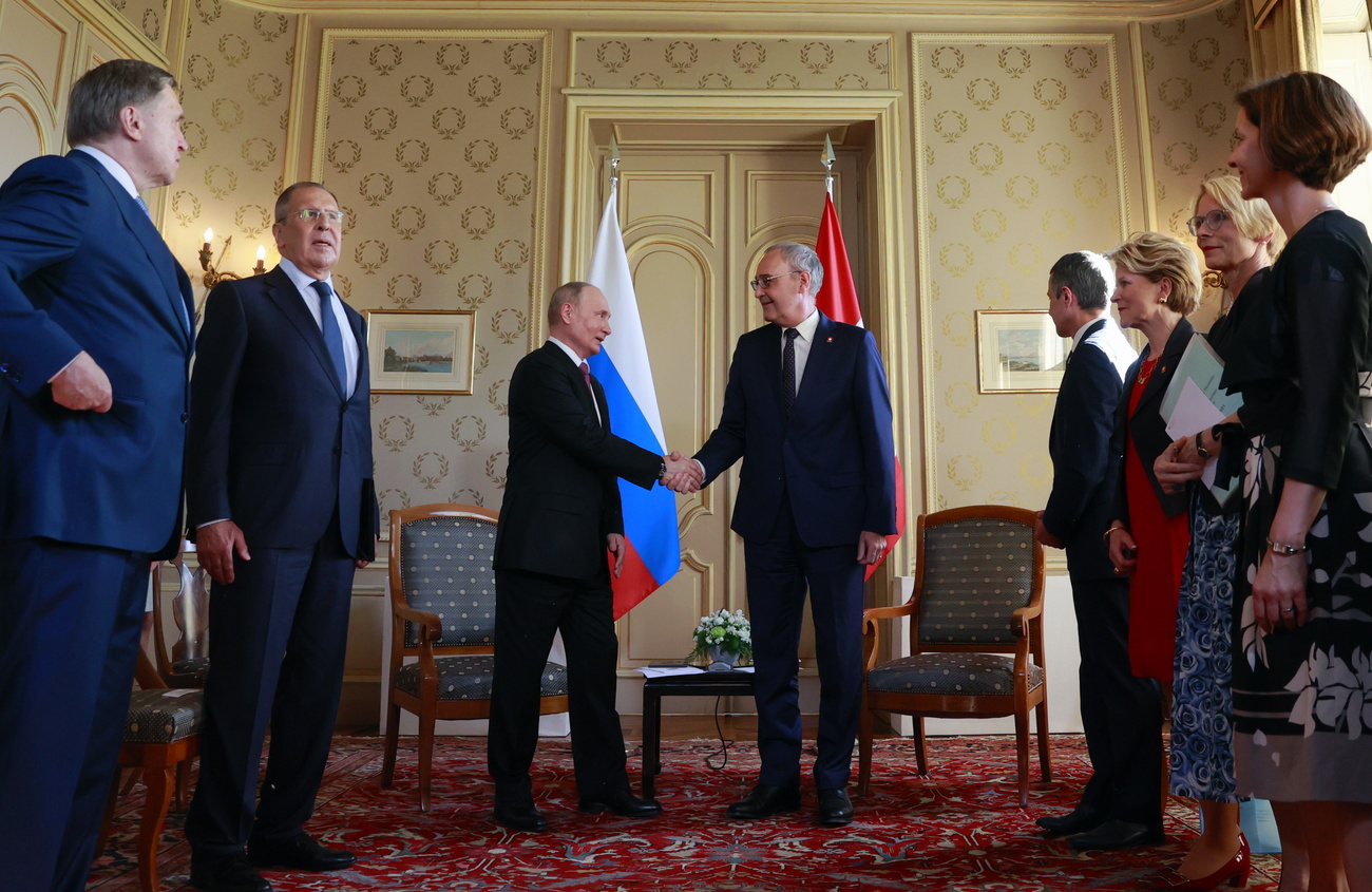 El presidente suizo Guy Parmelin y Vladimir Putin se estrechan la mano