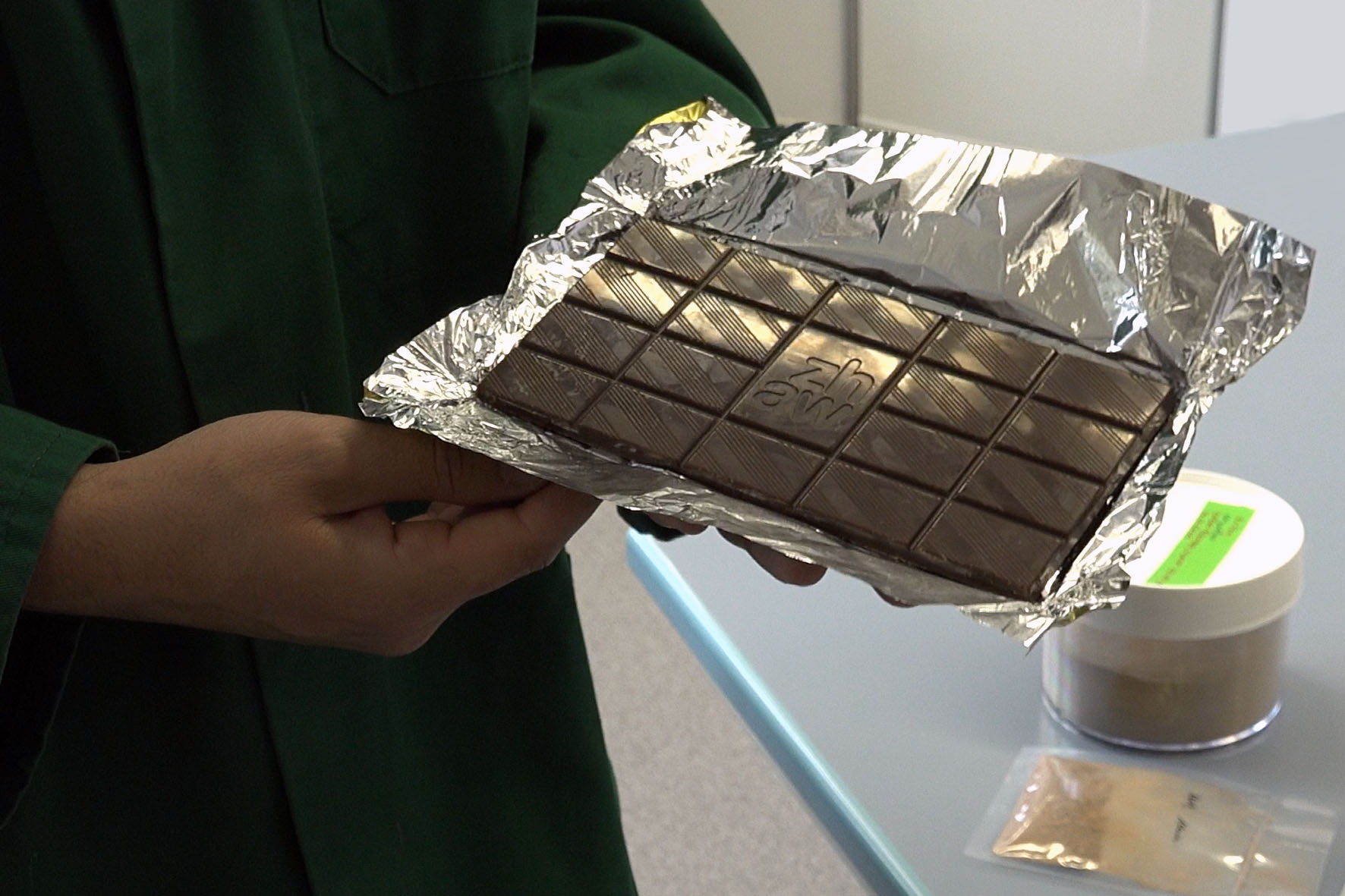 Mann zeigt Schokolade aus dem Labor
