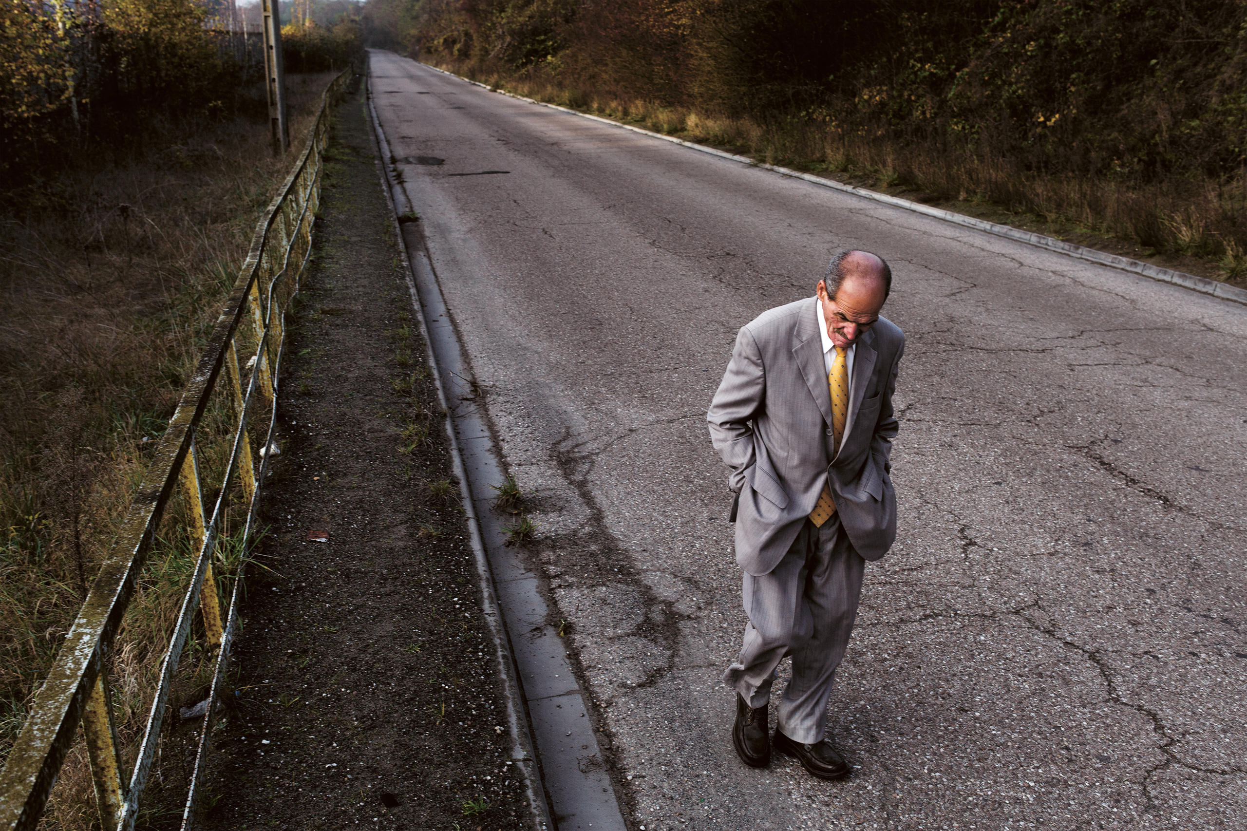 Vieil homme sur une route de campagne isolée