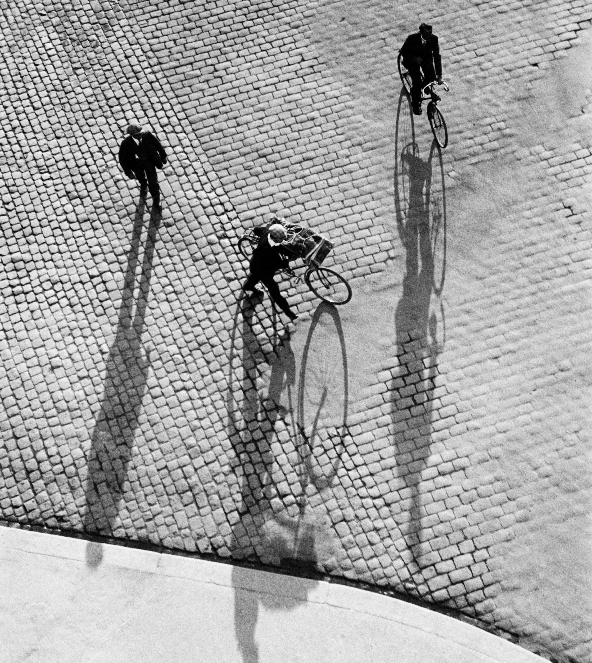 Tres personas, dos en bicicleta, en la Bahnhofplatz de Zürich, 1933