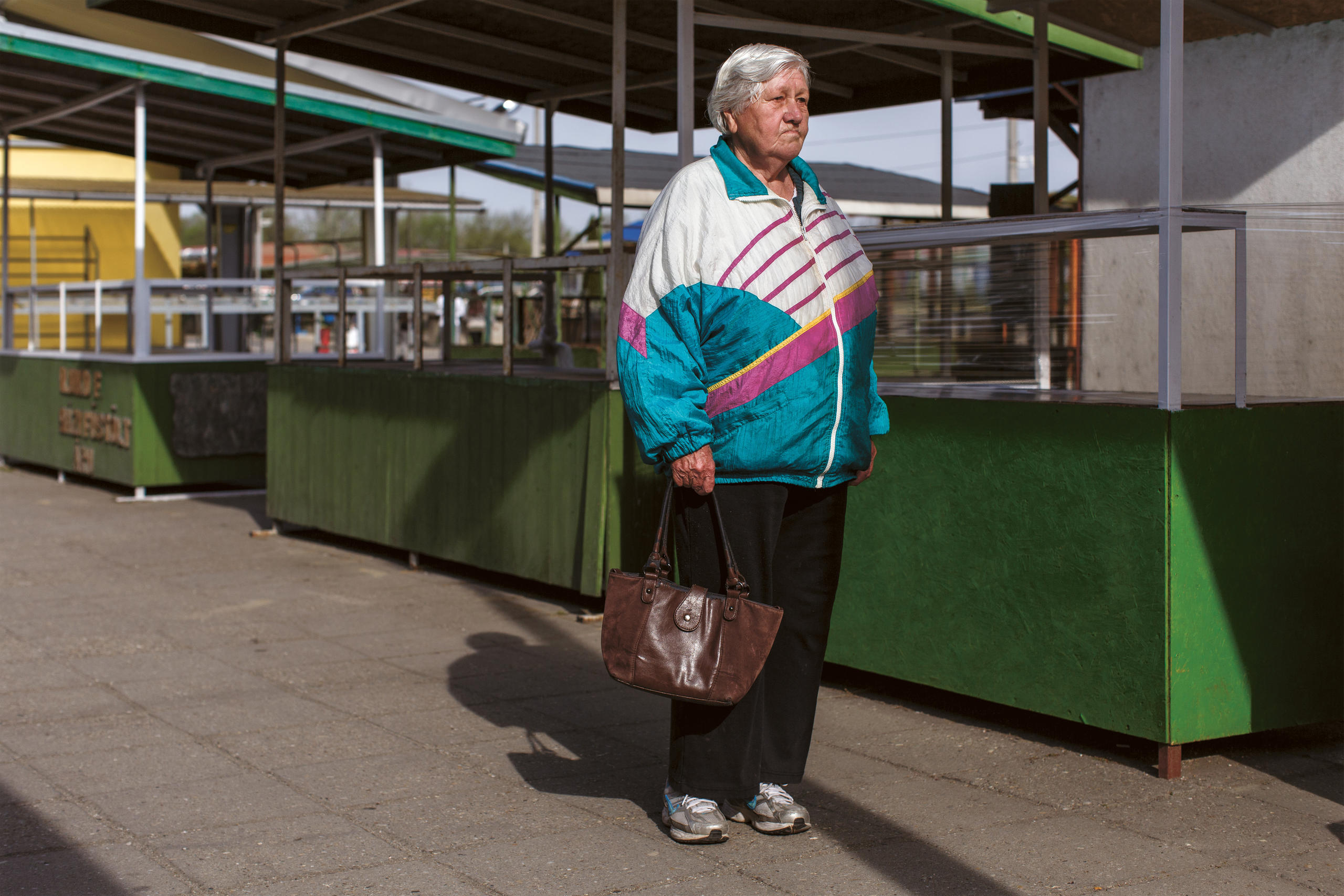 Frau in ärmlicher Kleidung mit Einkaufstasche