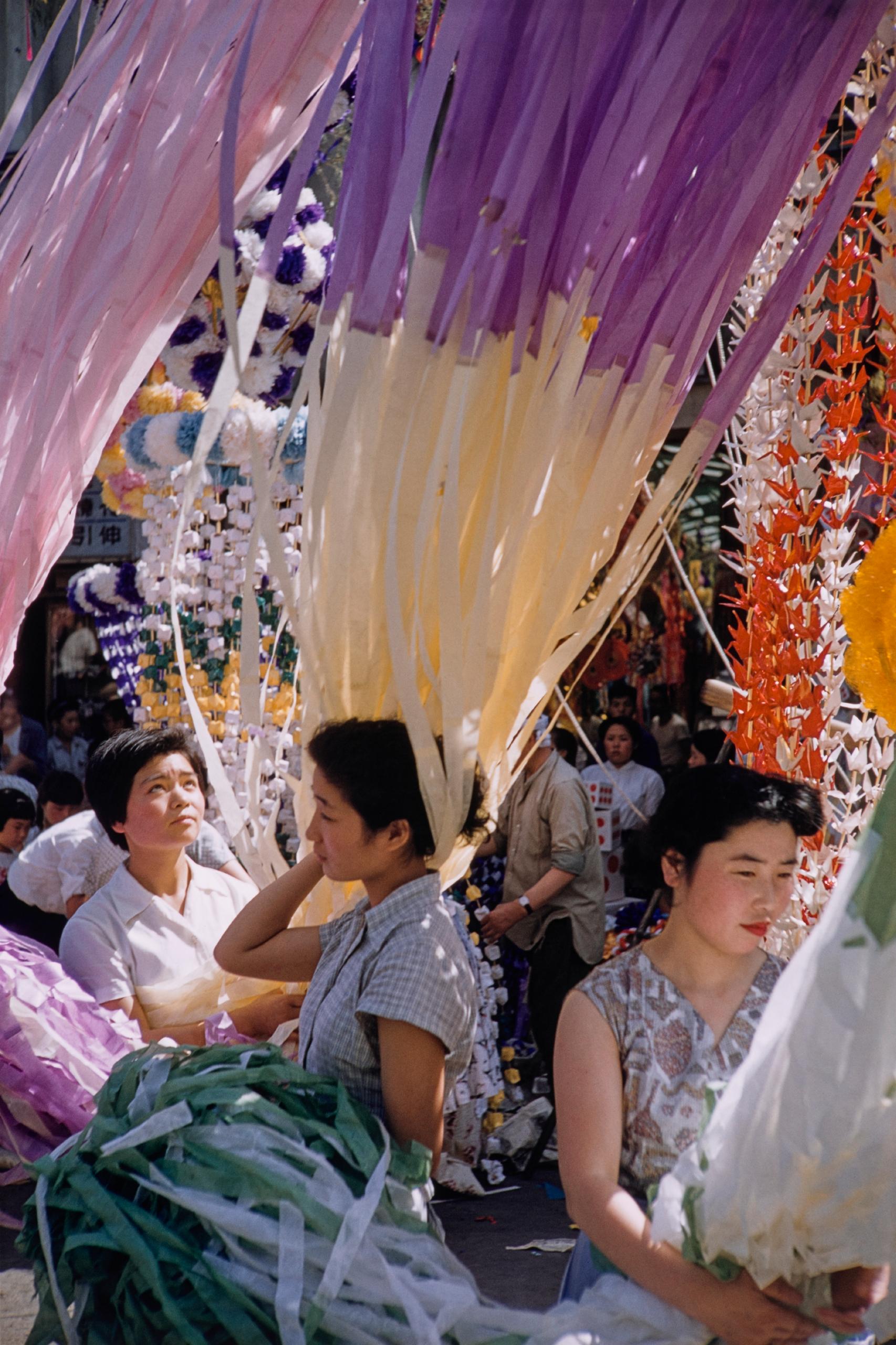 Mujeres japonesas sentadas en el suelo entre cortinas