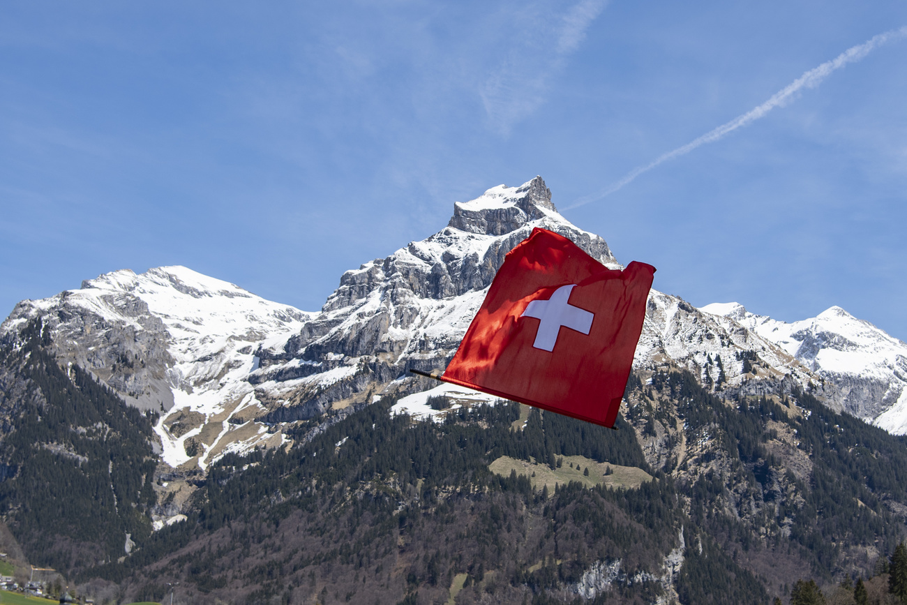 bandiera svizzera sventola davanti a una montagna